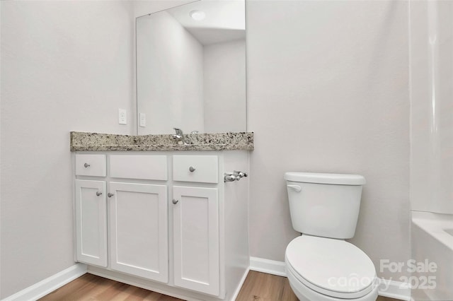 full bath with vanity, toilet, wood finished floors, and baseboards