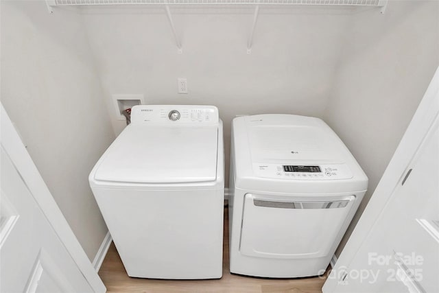 laundry room featuring laundry area, washing machine and dryer, and light wood-type flooring