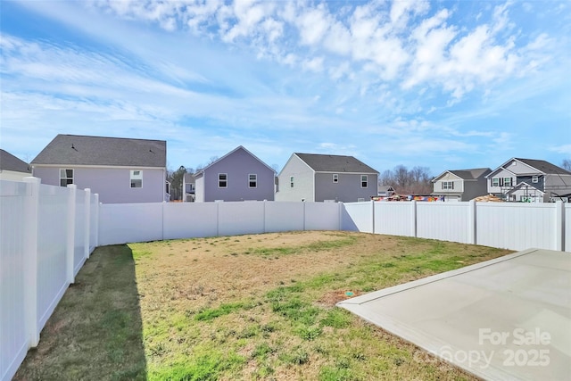 view of yard with a residential view, a patio, and a fenced backyard