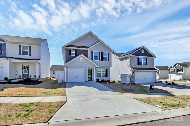 view of front of property with a residential view, concrete driveway, and a garage