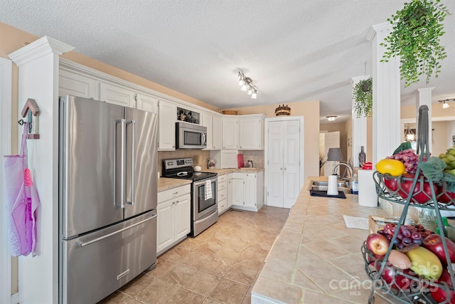 kitchen with white cabinetry, stainless steel appliances, a textured ceiling, and a sink