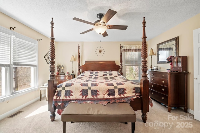 bedroom with a ceiling fan, baseboards, visible vents, a textured ceiling, and light carpet