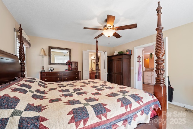 carpeted bedroom with connected bathroom, baseboards, and ceiling fan