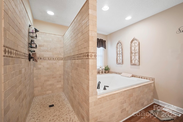 bathroom with a garden tub, recessed lighting, and tiled shower