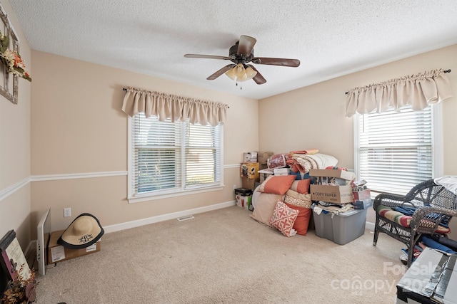 bedroom featuring carpet, visible vents, baseboards, ceiling fan, and a textured ceiling