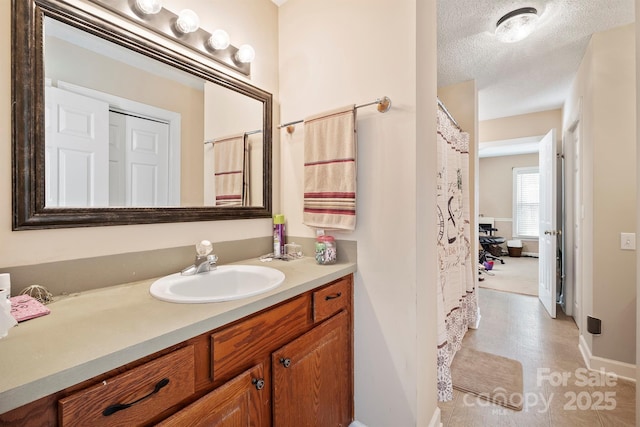 full bathroom featuring a textured ceiling and vanity