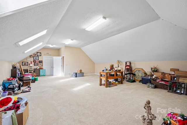 game room with lofted ceiling with skylight, a textured ceiling, and carpet