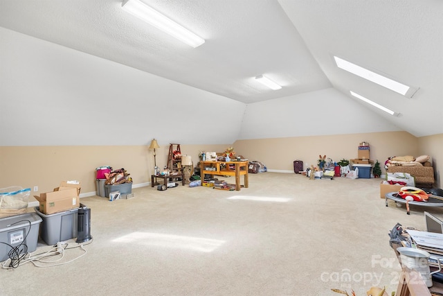 game room with baseboards, lofted ceiling with skylight, carpet, and a textured ceiling