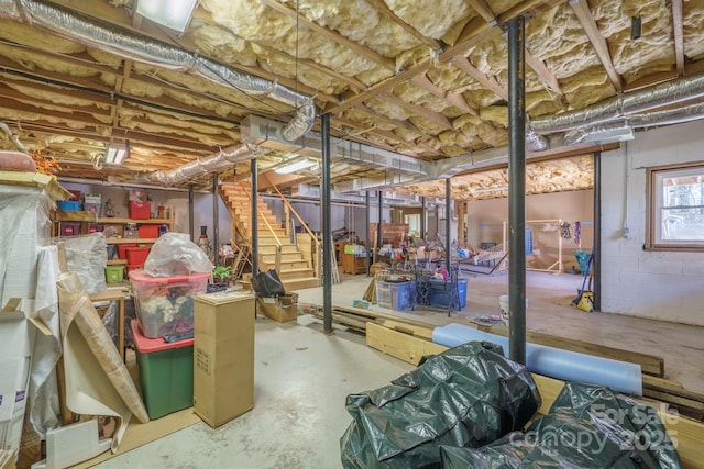 basement with concrete block wall and stairs