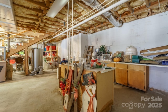 unfinished basement with stairs and water heater