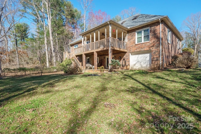 back of property with a yard, an attached garage, ceiling fan, stairs, and brick siding