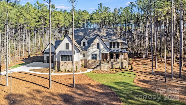 4354 Persimmon Rd, Lancaster, SC 29720 - view of front of home featuring board and batten siding, concrete driveway, a front yard, and stone siding