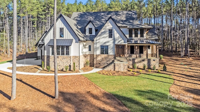 4354 Persimmon Rd, Lancaster, SC 29720 - view of front of home with board and batten siding, covered porch, a front yard, and stone siding
