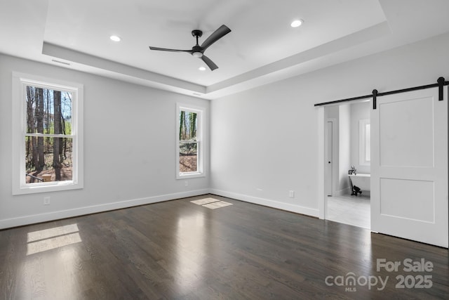3732 Whitney Dr NE, Hickory, NC 28601 - unfurnished bedroom featuring a tray ceiling, a barn door, multiple windows, recessed lighting, and wood finished floors