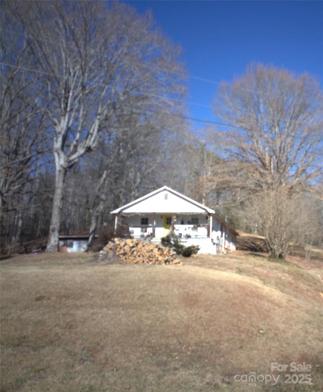 view of side of home with a yard and covered porch