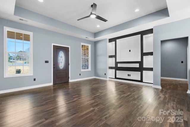 entrance foyer featuring a raised ceiling, baseboards, and wood finished floors