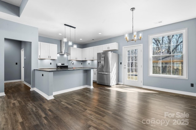 kitchen featuring visible vents, dark countertops, white cabinetry, stainless steel appliances, and wall chimney exhaust hood