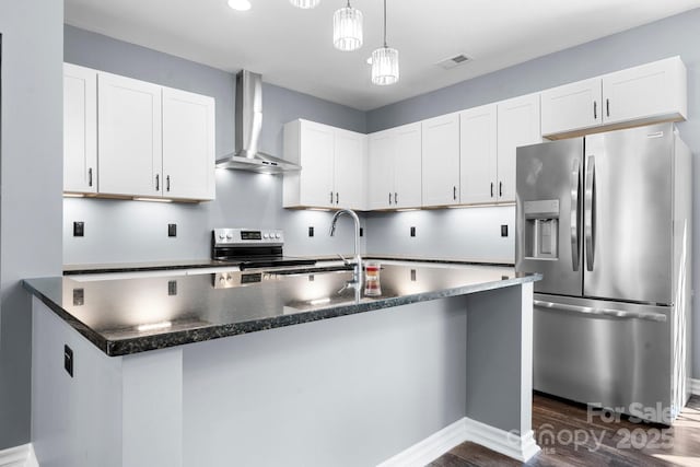 kitchen featuring appliances with stainless steel finishes, wall chimney exhaust hood, and white cabinets