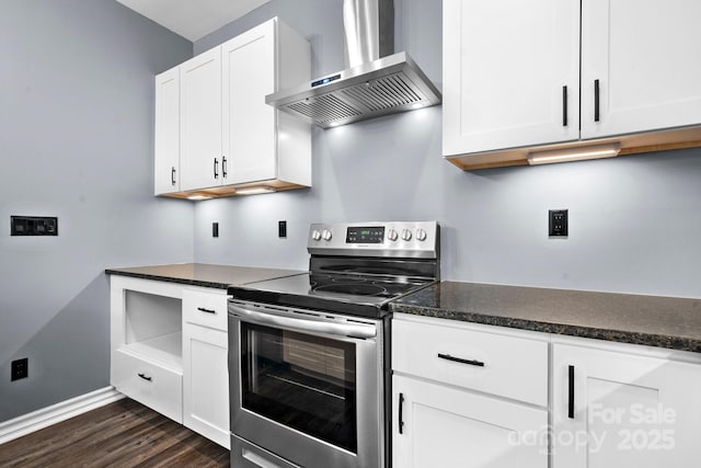 kitchen featuring white cabinetry, stainless steel electric range oven, wall chimney range hood, and dark countertops