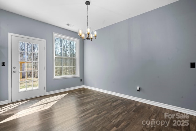 unfurnished dining area with a notable chandelier, visible vents, a healthy amount of sunlight, and dark wood-style flooring