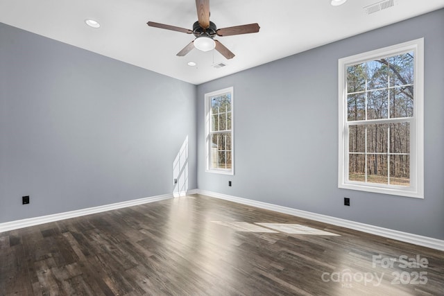 unfurnished room with visible vents, baseboards, and wood finished floors