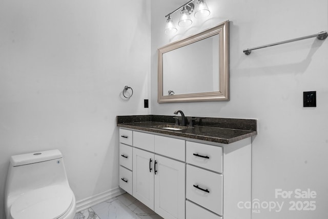 half bath featuring baseboards, marble finish floor, vanity, and toilet