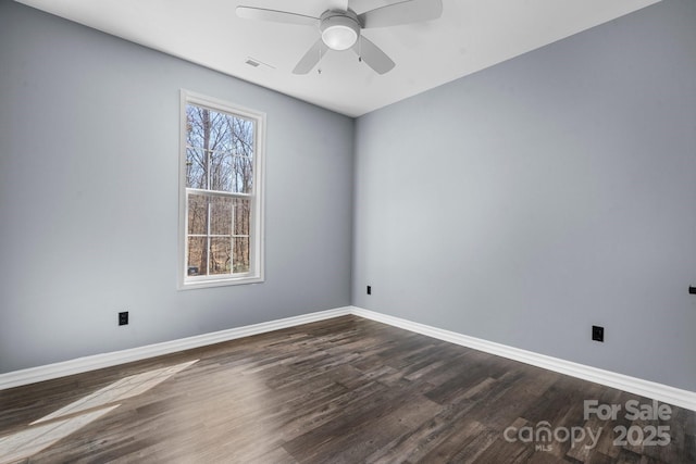 unfurnished room with baseboards, visible vents, dark wood-style flooring, and ceiling fan