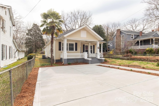 view of front facade featuring central air condition unit, a porch, and fence