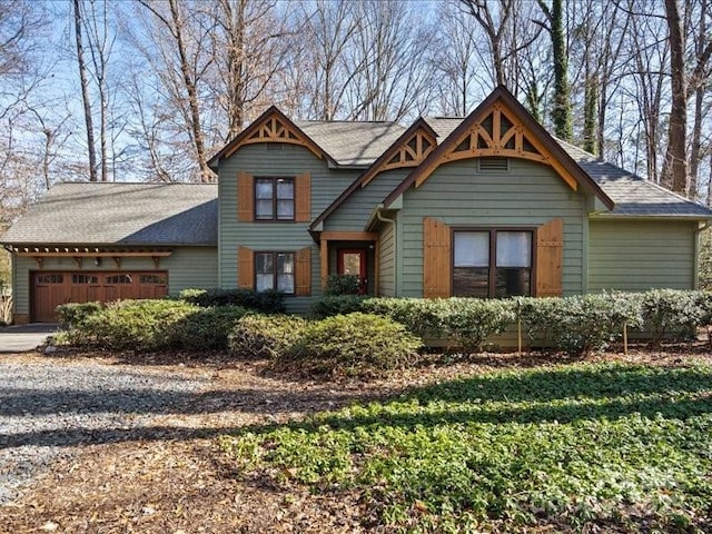 craftsman house featuring driveway, a garage, and roof with shingles