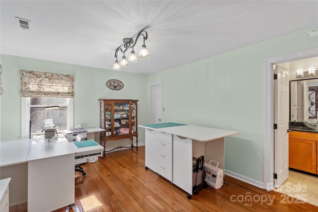 office area with visible vents, baseboards, an inviting chandelier, and light wood finished floors