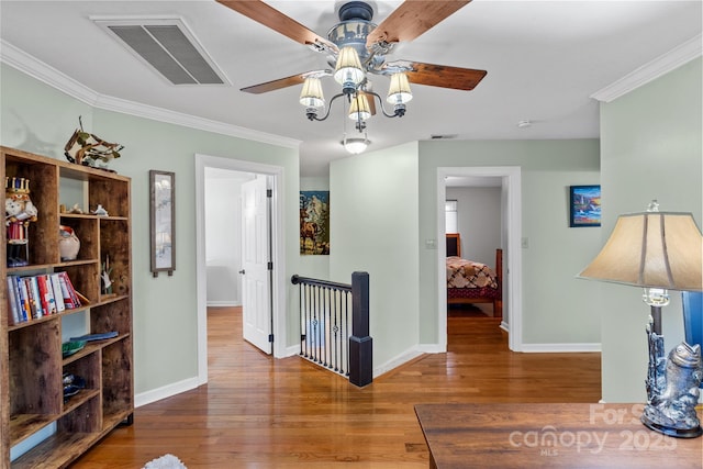 hallway with visible vents, an upstairs landing, wood finished floors, and crown molding