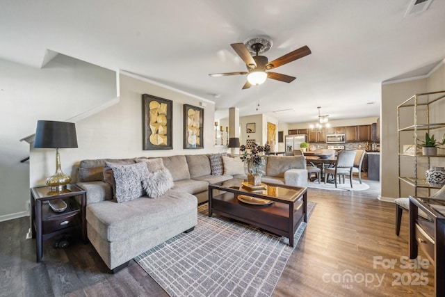 living area with visible vents, crown molding, baseboards, dark wood-type flooring, and a ceiling fan