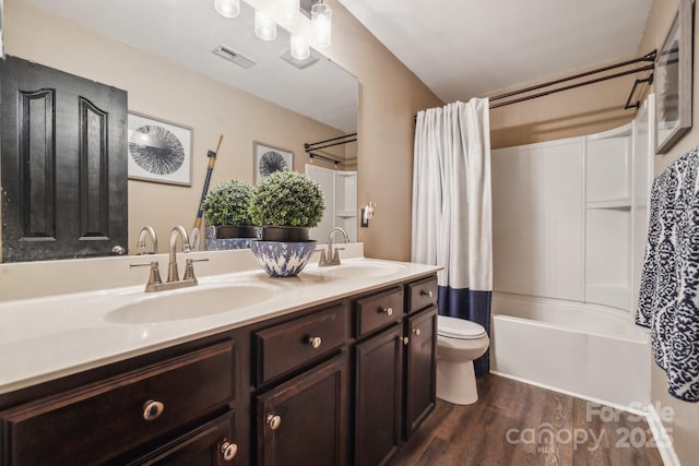 full bathroom featuring toilet, wood finished floors, visible vents, and a sink