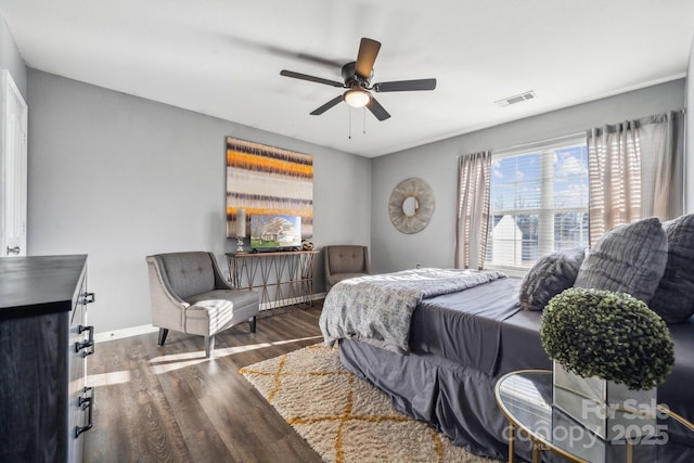 bedroom with visible vents, a ceiling fan, baseboards, and wood finished floors