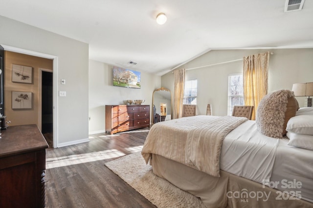 bedroom featuring visible vents, baseboards, dark wood-style floors, and vaulted ceiling