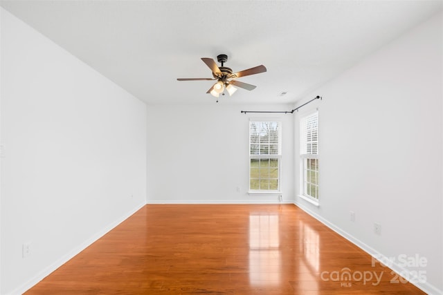 unfurnished room with wood finished floors, baseboards, and ceiling fan