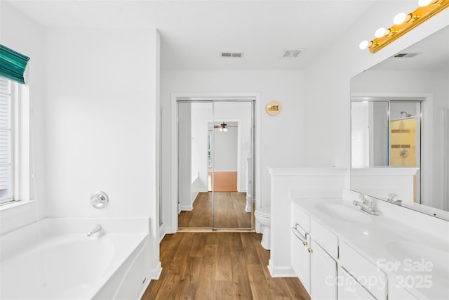 full bath featuring a bath, visible vents, toilet, and a sink