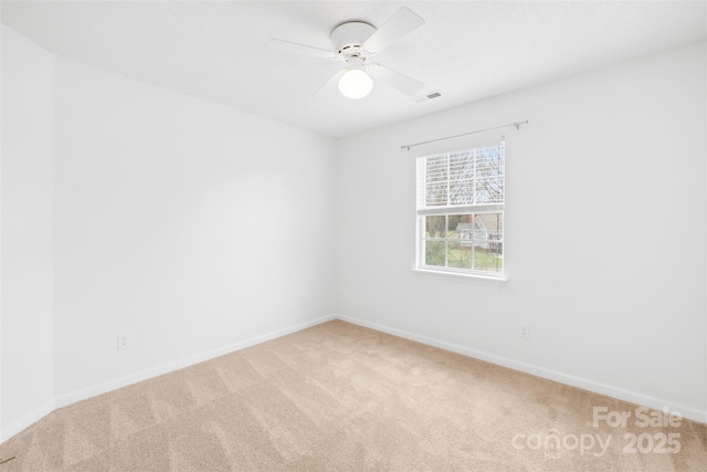 carpeted empty room featuring visible vents, baseboards, and ceiling fan