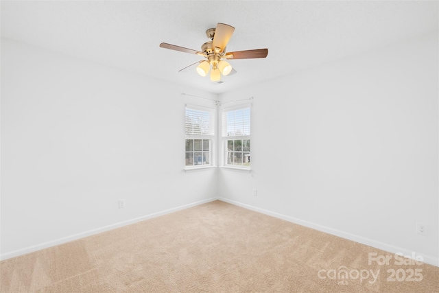 spare room featuring light colored carpet, baseboards, and ceiling fan