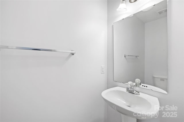 bathroom featuring visible vents and a sink