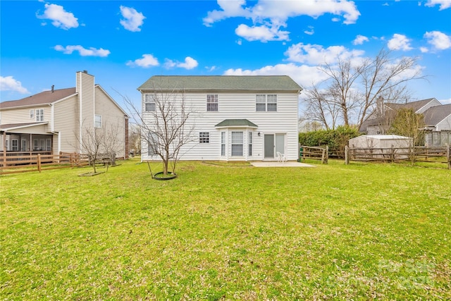 rear view of house featuring a yard, fence, and a patio area