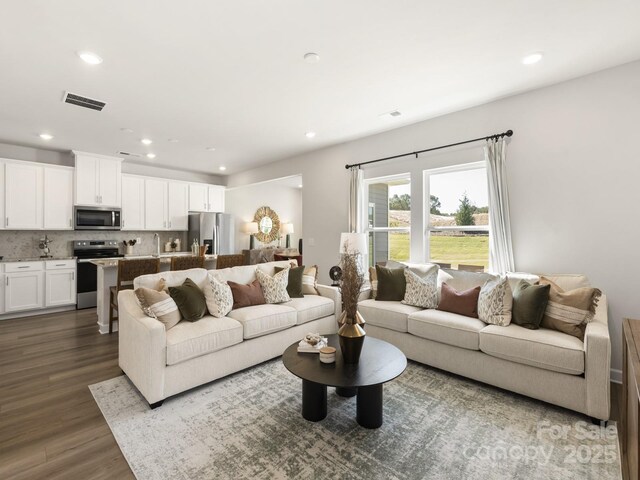 living area featuring visible vents, recessed lighting, and dark wood-style flooring