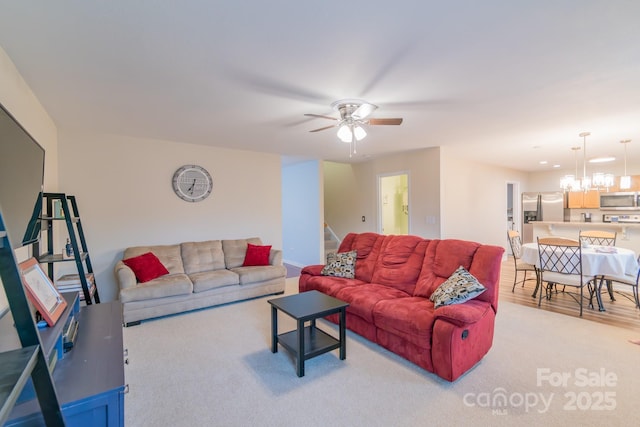 living room featuring stairs, light wood-style floors, and ceiling fan