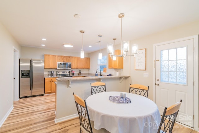 dining room with recessed lighting, light wood-style floors, and baseboards