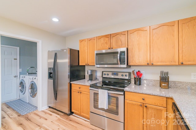 kitchen with light wood finished floors, separate washer and dryer, recessed lighting, and appliances with stainless steel finishes