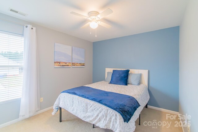 carpeted bedroom featuring visible vents, baseboards, and a ceiling fan