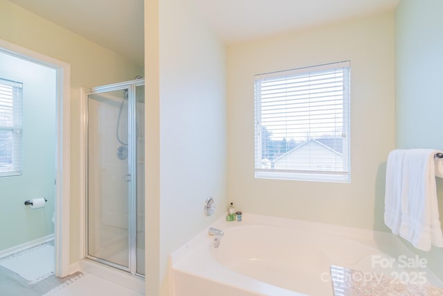 full bathroom featuring a stall shower and a garden tub