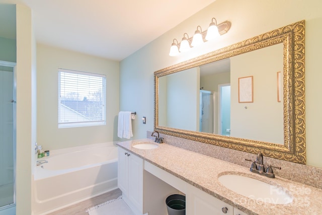 full bathroom featuring a bath, a shower stall, double vanity, and a sink