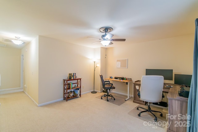 carpeted office space with baseboards and ceiling fan