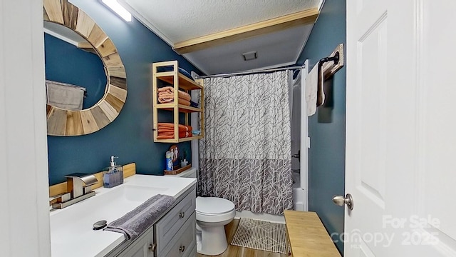 bathroom with toilet, shower / tub combo with curtain, vanity, wood finished floors, and a textured ceiling